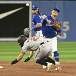 
              Toronto Blue Jays third baseman Matt Chapman, right, throws to first base, but not in time to complete the double play on Baltimore Orioles' Cedric Mullins, after forcing out Ryan McKenn at second base during hte ninth inning of a baseball game Tuesday, Aug. 16, 2022, in Toronto. (Jon Blacker/The Canadian Press via AP)
            