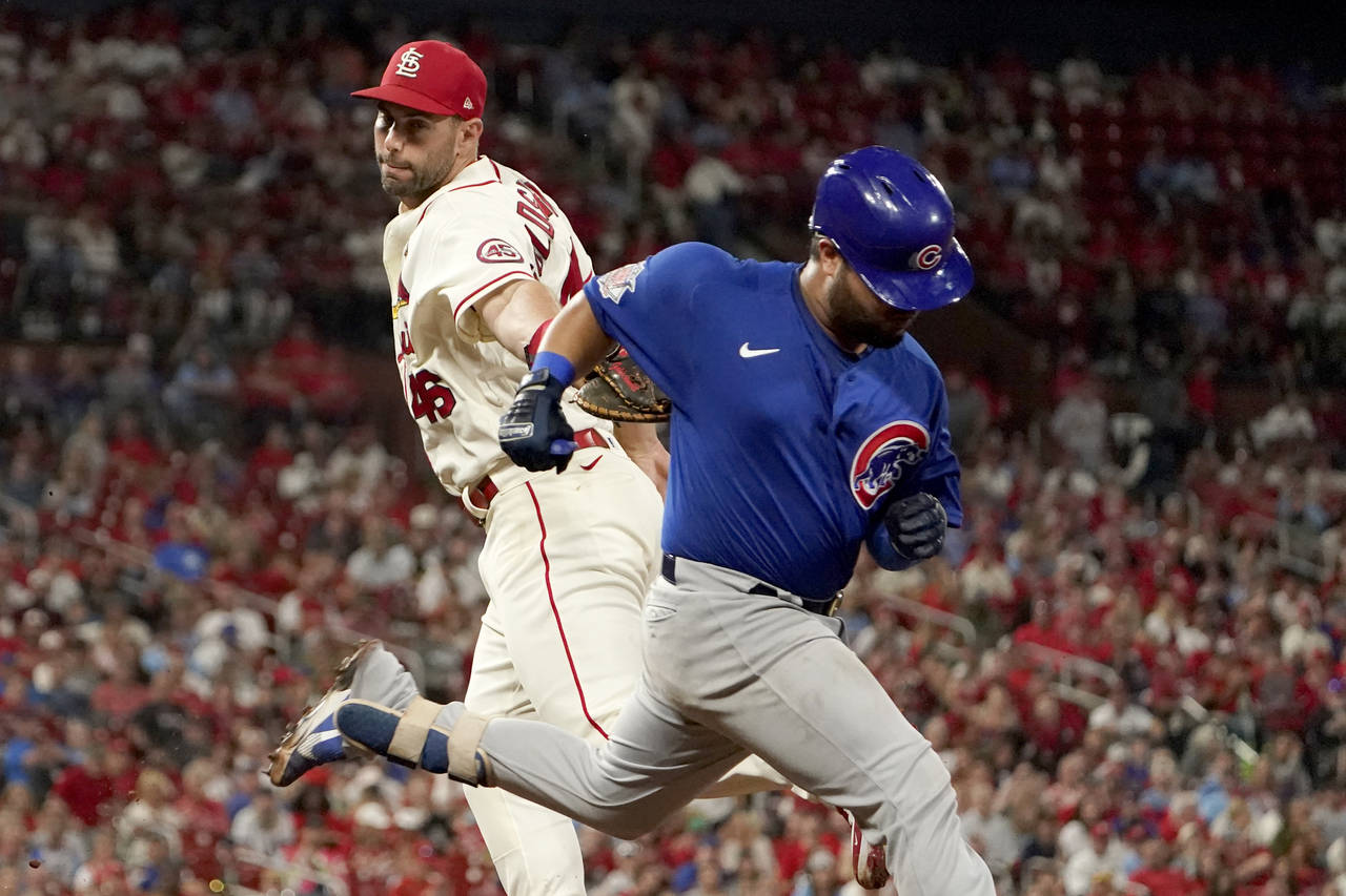 FILE - Chicago Cubs' Erick Castillo, right, is safe at first for a single as he avoids the tag from...