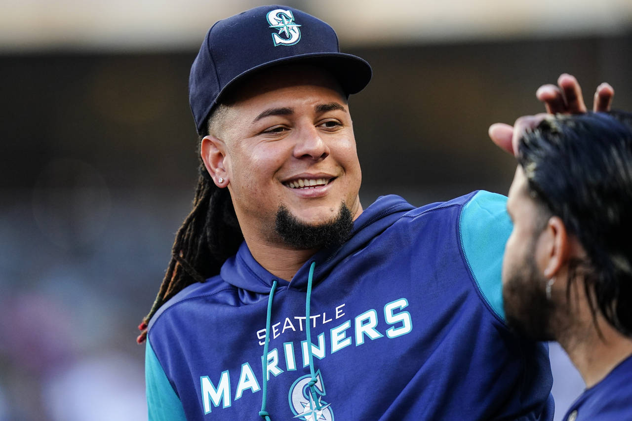 Seattle Mariners' Luis Castillo talks to a teammate during the first inning of a baseball game agai...