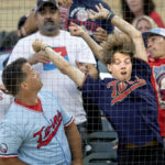 
              Fans reach for a foul ball in the fourth inning of a baseball game between the Kansas City Royals and the Minnesota Twins on Tuesday, Aug. 16, 2022, in Minneapolis. (Carlos Gonzalez/Star Tribune via AP)
            