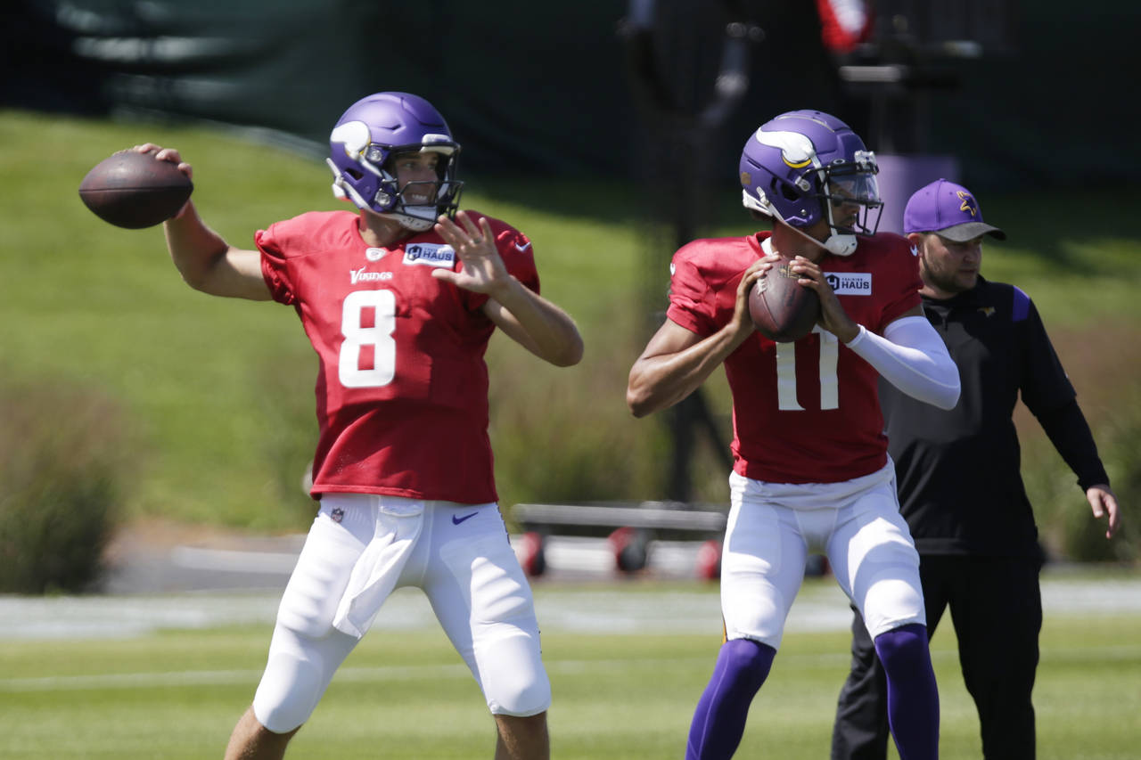 Minnesota Vikings quarterback Kirk Cousins (8) and Vikings quarterback Kellen Mond prepare to throw...
