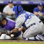 
              Texas Rangers catcher Meibrys Viloria, right, loses the ball after tagging out Colorado Rockies' Elias Diaz as he tries to score in the eighth inning of a baseball game Tuesday, Aug. 23, 2022, in Denver. (AP Photo/David Zalubowski)
            