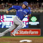 
              Toronto Blue Jays' Whit Merrifield rounds third and scores from second base against the Minnesota Twins on a two-run single by George Springer during the eighth inning of a baseball game Thursday, Aug. 4, 2022, in Minneapolis. (AP Photo/Bruce Kluckhohn)
            
