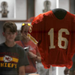 
              A fan looks at the jersey of former Kansas City Chiefs quarterback Len Dawson before the start of an NFL preseason football game between the Kansas City Chiefs and the Green Bay Packers Thursday, Aug. 25, 2022, in Kansas City, Mo. Dawson, who helped the Kansas City Chiefs to their first Super Bowl title and is in the Pro Football Hall of Fame as a player and broadcaster, died Wednesday at the age of 87. (AP Photo/Charlie Riedel)
            