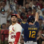 
              Milwaukee Brewers' Hunter Renfroe (12) celebrates alongside St. Louis Cardinals third baseman Nolan Arenado (28) after hitting an RBI triple during the 10th inning of a baseball game Saturday, Aug. 13, 2022, in St. Louis. (AP Photo/Jeff Roberson)
            