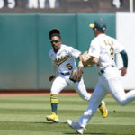 
              Oakland Athletics left fielder Tony Kemp (5) and shortstop Nick Allen (2) are unable to catch a fly ball hit by Seattle Mariners' Dylan Moore who singled during the second inning of a baseball game in Oakland, Calif., Sunday, Aug. 21, 2022. (AP Photo/Godofredo A. Vásquez)
            