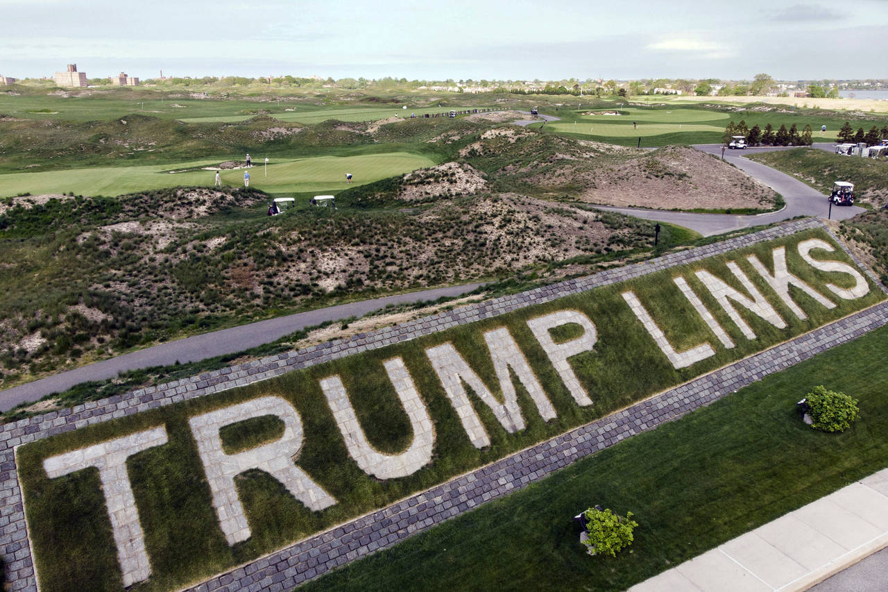 FILE - Patrons play the links as a giant branding sign is displayed with flagstones at Trump Golf L...