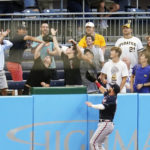 
              Atlanta Braves left fielder Robbie Grossman jumps on the wall chasing a home run ball by Pittsburgh Pirates' Michael Chavis that a fans look to catch during the second inning of a baseball game, Tuesday, Aug. 23, 2022, in Pittsburgh. (AP Photo/Keith Srakocic)
            