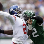 
              New York Giants quarterback Tyrod Taylor (2) passes before taking a hard hit from New York Jets defensive end Micheal Clemons (72) in the first half of a preseason NFL football game, Sunday, Aug. 28, 2022, in East Rutherford, N.J. (AP Photo/Adam Hunger)
            