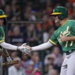 
              Oakland Athletics' Jonah Bride, right, slaps hands with Nick Allen after scoring on a two-RBI double by pinch hitter Skye Bolt during the seventh inning of a baseball game Friday, Aug. 12, 2022, in Houston. (AP Photo/Kevin M. Cox)
            