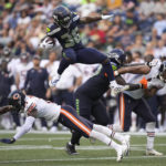 
              Seattle Seahawks running back Darwin Thompson (36) leaps over Chicago Bears safety A.J. Thomas during the second half of a preseason NFL football game, Thursday, Aug. 18, 2022, in Seattle. (AP Photo/Stephen Brashear)
            