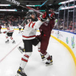 
              Canada's Will Cuylle (27) checks Latvia's Niks Fenenko (4) during the second period of an IIHF junior world hockey championships game Wednesday, Aug. 10, 2022, in Edmonton, Alberta. (Jason Franson/The Canadian Press)
            