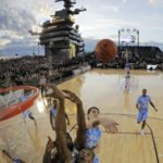 
              FILE - In this Nov. 11, 2011, file photo, in this image taken with a fisheye lens, North Carolina forward Tyler Zeller (44) swats the rebound away from Michigan State center Adreian Payne, bottom, during the first half of the Carrier Classic NCAA college basketball game aboard the USS Carl Vinson in Coronado, Calif., Nov. 11, 2011. The second “Field of Dreams” baseball game is Thursday night, Aug. 11, 2022,  in the cornfields of eastern Iowa, near the site of the beloved 1989 movie. If Major League Baseball is looking for another place for a game, oh man, do we have some fun ideas. (AP Photo/Mark J. Terrill, File)
            