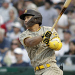 
              San Diego Padres' Ha-Seong Kim follows through on a ground rule double during the second inning of a baseball game against the Washington Nationals, Saturday, Aug.13, 2022, in Washington. (AP Photo/Luis M. Alvarez)
            