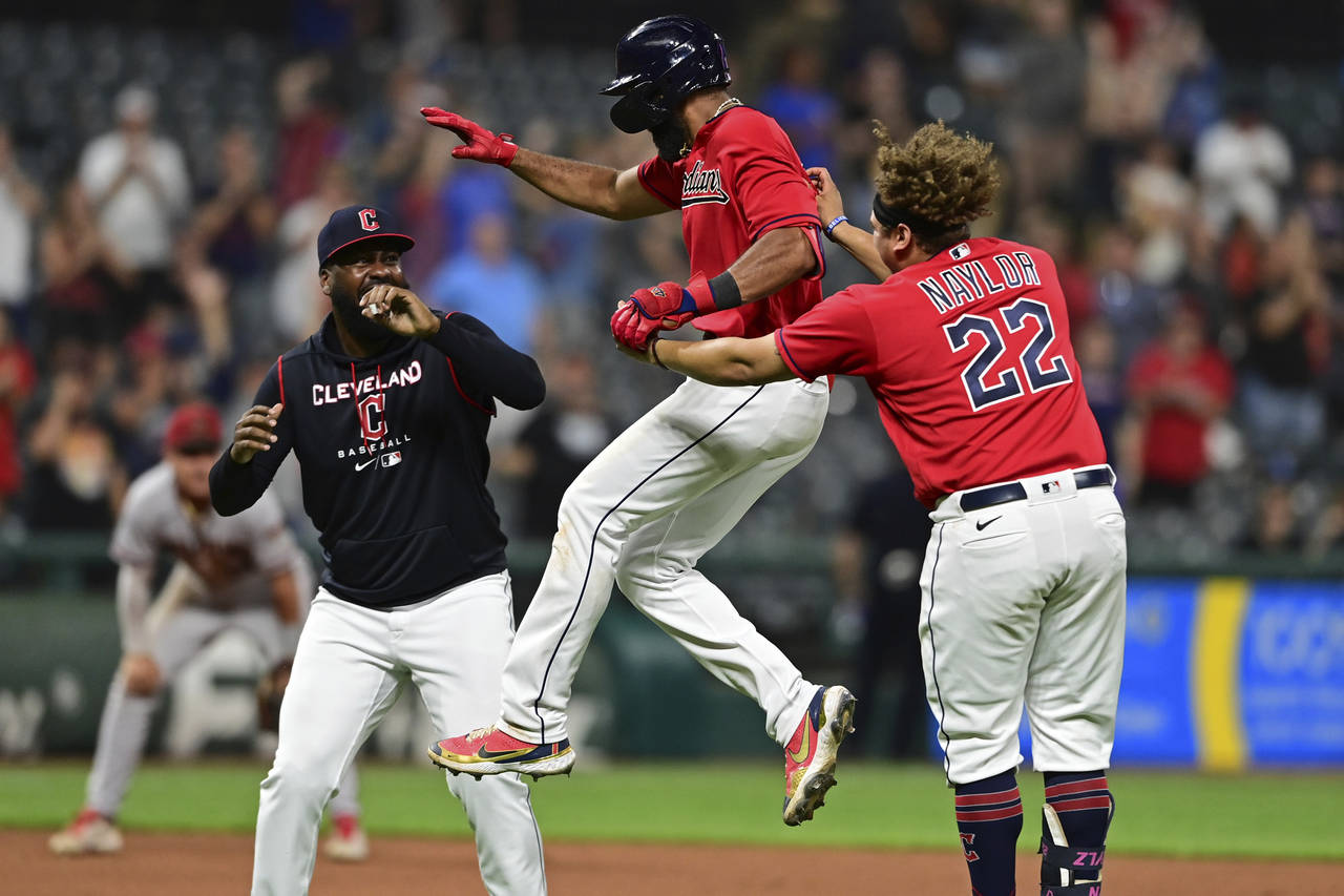 Cleveland Guardians' Amed Rosario, center, celebrates with Josh Naylor (22) and Franmil Reyes, left...