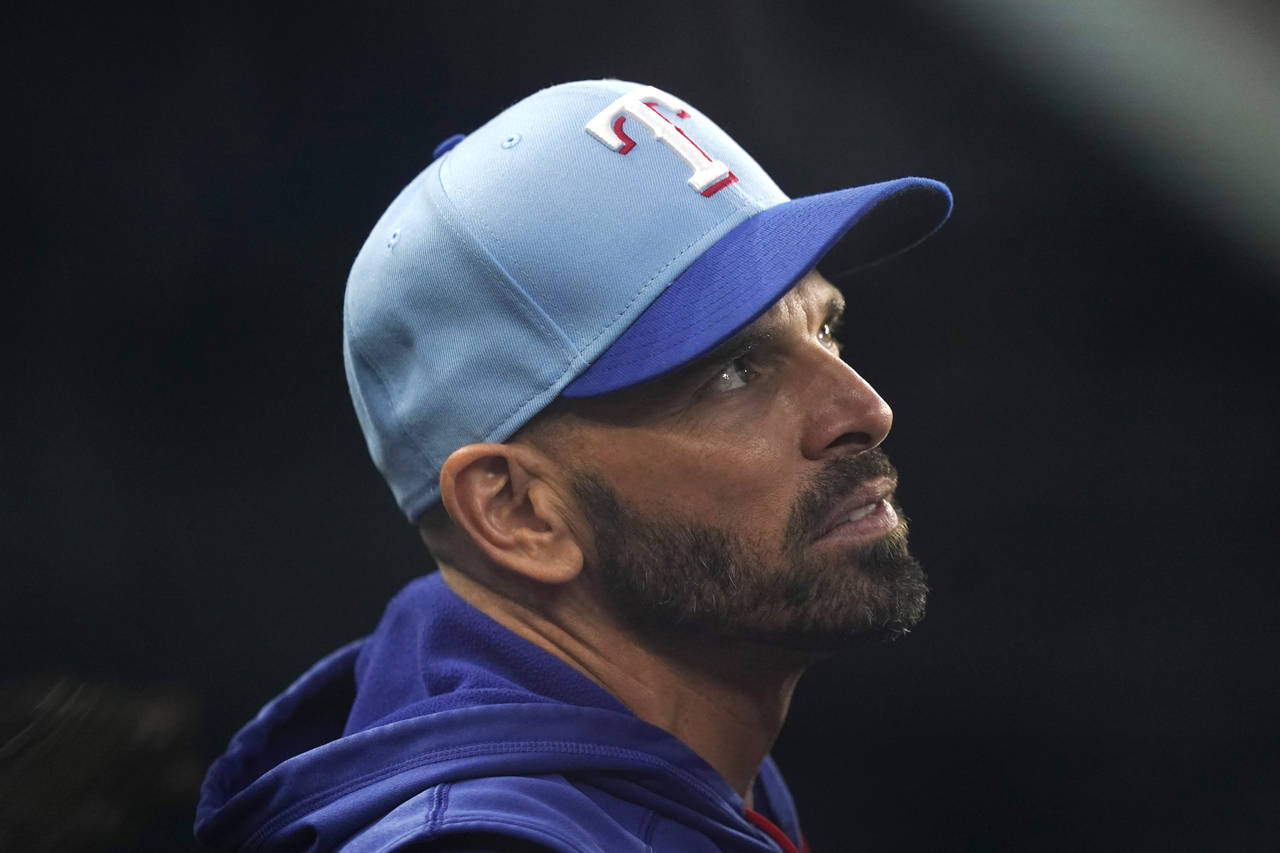 Texas Rangers manager Chris Woodward looks out from the dugout before the team's baseball game agai...