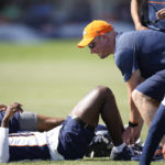 
              Denver Broncos head coach Nathaniel Hackett, right, ties the shoe of wide receiver Montrell Washington as he stretches before taking part in drills during the NFL football team's training camp Friday, Aug. 5, 2022, at the Broncos' headquarters in Centennial, Colo. (AP Photo/David Zalubowski)
            