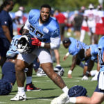 
              Tennessee Titans defensive tackle Jeffery Simmons, center, stretches before a combined NFL football training camp with the Tampa Bay Buccaneers, Thursday, Aug. 18, 2022, in Nashville, Tenn. (AP Photo/Mark Zaleski)
            
