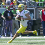 
              Oregon quarterback Bo Nix (10) scrambles as the team holds its annual spring football game at Autzen Stadium in Eugene, Ore., Saturday, April 23, 2022. Oregon first-year coach Dan Lanning isn't dropping any clues about his starting quarterback this season. Fall camp has been a battle behind closed doors between transfer Nix and redshirt freshmen Ty Thompson and Jay Butterfield. (Sean Meagher/The Oregonian via AP)
            