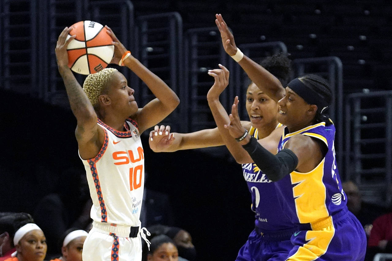 Connecticut Sun guard Courtney Williams, left, tries to pass while under pressure from Los Angeles ...