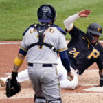 
              Pittsburgh Pirates' Greg Allen, right, scores from third as Milwaukee Brewers catcher Victor Caratini, left, walks back to the plate with the ball after giving up a passed ball in the second inning of a baseball game, Thursday, Aug. 4, 2022, in Pittsburgh. (AP Photo/Keith Srakocic)
            