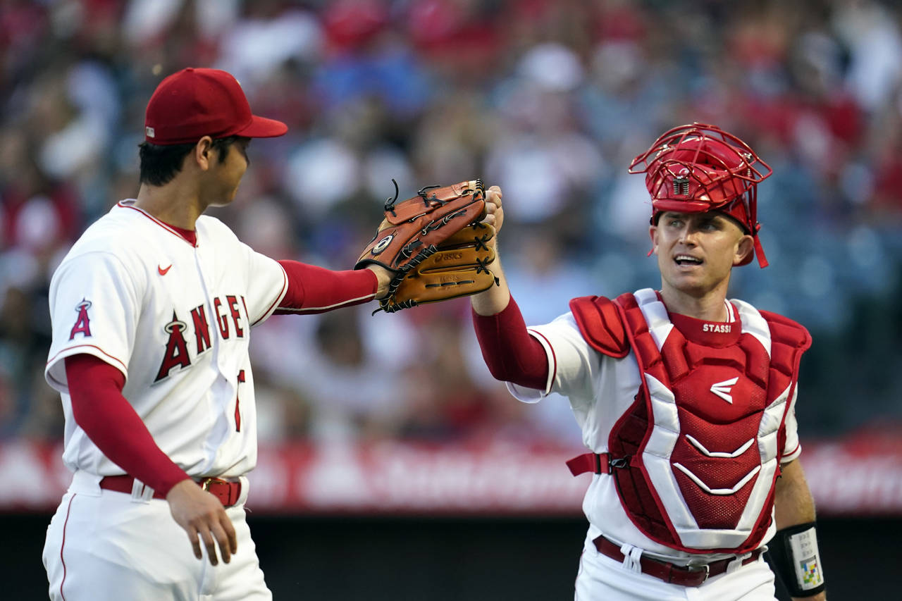 Los Angeles Angels starting pitcher Shohei Ohtani, left, taps gloves with Max Stassi at the end of ...
