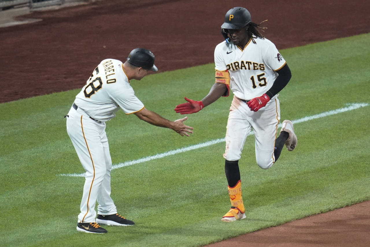 Pittsburgh Pirates' Oneil Cruz (15) is greeted by third base coach Mike Rabelo (58) as he runs the ...