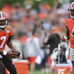 
              Cleveland Browns quarterback Deshaun Watson, right, watches as quarterback Jacoby Brissett participates in a drill during an NFL football practice in Berea, Ohio, Sunday, Aug. 14, 2022. (AP Photo/David Dermer)
            