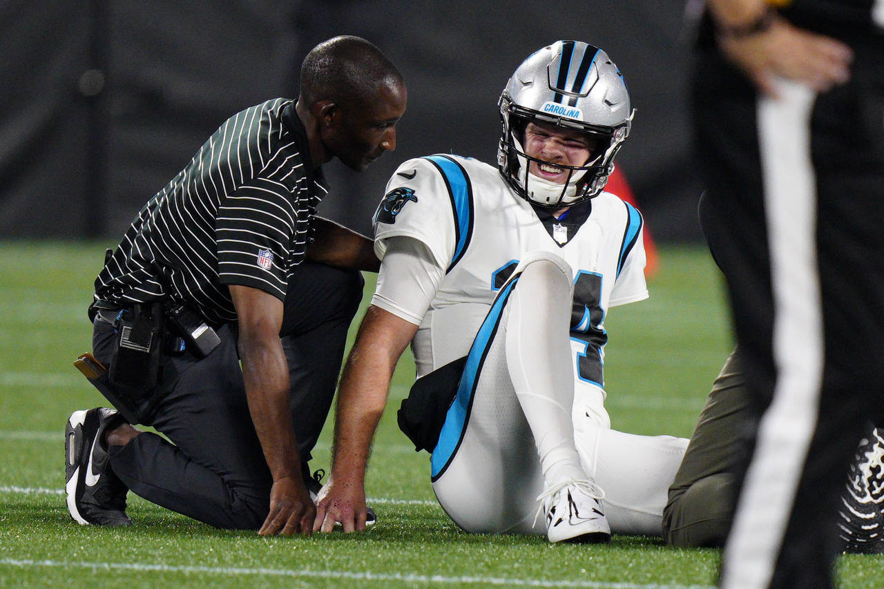 Carolina Panthers quarterback Sam Darnold is treated after getting injured during the second half o...