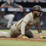 
              San Diego Padres' Jurickson Profar trips on the bat after attempting a bunt in the sixth inning at a baseball game against the Miami Marlins, Wednesday, Aug. 17, 2022, in Miami. (AP Photo/Marta Lavandier)
            