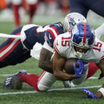 
              New York Giants wide receiver Collin Johnson (15) is brought down by New England Patriots cornerback Terrance Mitchell during the first half of a preseason NFL football game Thursday, Aug. 11, 2022, in Foxborough, Mass. (AP Photo/Charles Krupa)
            