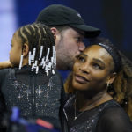 
              Serena Williams, of the United States, gets a kiss from her husband Alexis Ohanian as their daughter Olympia looks on after Williams defeated Danka Kovinic, of Montenegro, during the first round of the US Open tennis championships, Monday, Aug. 29, 2022, in New York. (AP Photo/Charles Krupa)
            