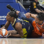
              Dallas Wings center Teaira McCowan (7) grabes the loose ball in front of Connecticut Sun forward Alyssa Thomas (25) during the first quarter of Game 3 of a WNBA first-round playoff series basketball game in Arlington, Texas, Wednesday, Aug. 24, 2022. (AP Photo/LM Otero)
            