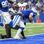 
              Indianapolis Colts quarterback Sam Ehlinger (4) is hit by Tampa Bay Buccaneers safety Chris Cooper (39) on the goal line after a 45-yard tun for a touchdown in the second half of an NFL preseason football game in Indianapolis, Saturday, Aug. 27, 2022. (AP Photo/AJ Mast)
            