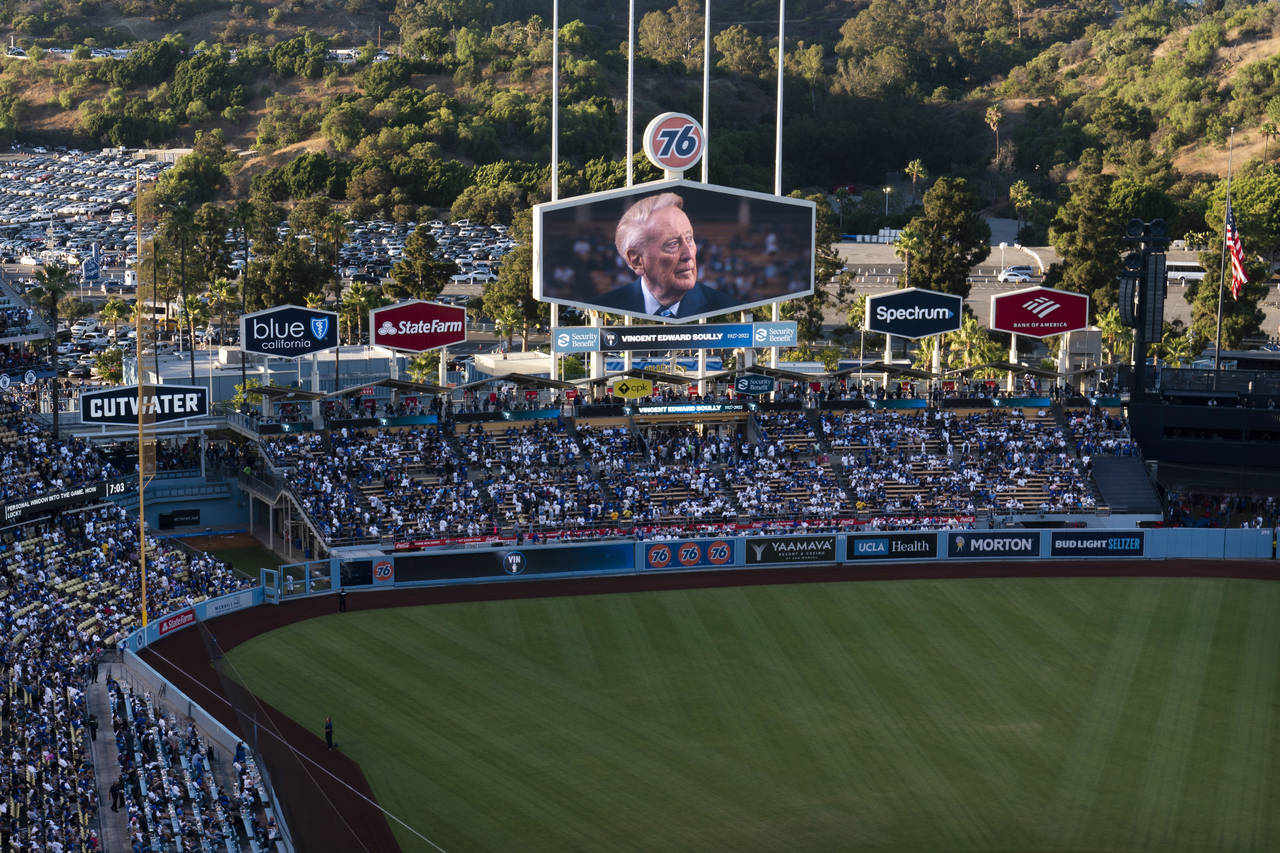 A screen at Dodger Stadium shows late broadcaster Vin Scully during a tribute to him before a baseb...