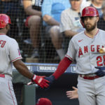 
              Los Angeles Angels' Luis Rengifo, left, is congratulated by Jared Walsh after scoring a run during the first inning of the team's baseball game against the Seattle Mariners, Friday, Aug. 5, 2022, in Seattle. (AP Photo/Stephen Brashear)
            