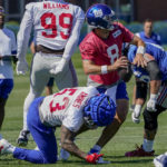 
              New York Giants quarterback Daniel Jones (8) is sacked on a play by linebacker Oshane Ximines (53) during training camp at the NFL football team's practice facility, Saturday, July 30, 2022, in East Rutherford, N.J. (AP Photo/John Minchillo)
            