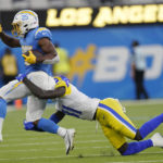 
              Los Angeles Chargers running back Joshua Kelley (25) is tackled by Los Angeles Rams cornerback Robert Rochell during the first half of a preseason NFL football game Saturday, Aug. 13, 2022, in Inglewood, Calif. (AP Photo/Mark J. Terrill)
            