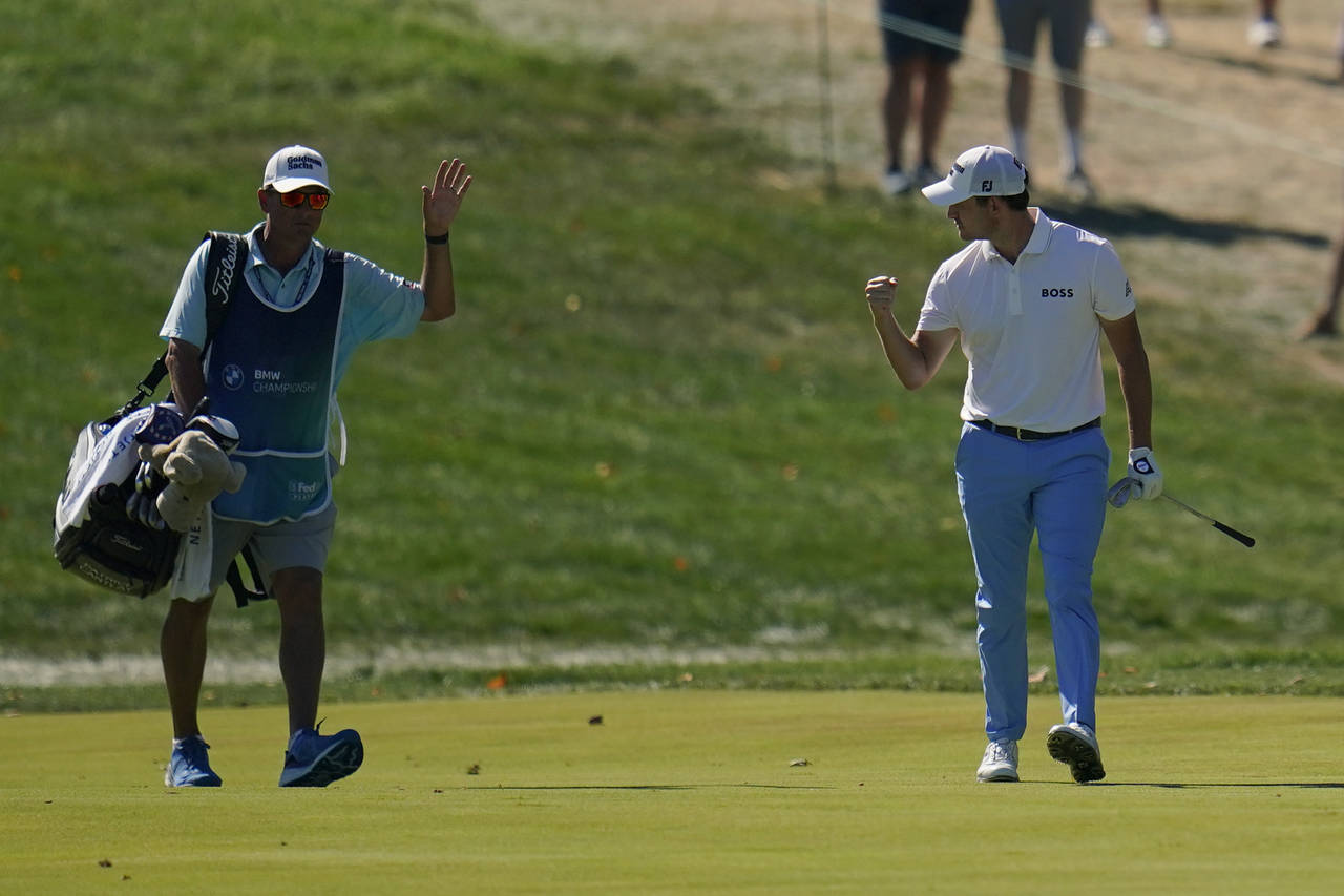 Patrick Cantlay, right, celebrates with his caddie after he holed out from the fairway on the 14th ...