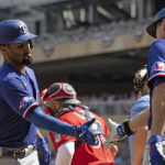 
              Texas Rangers' Marcus Semien, left, high-fives teammate Corey Seager, right, after hitting a home run during the fourth inning of a baseball game against the Minnesota Twins, Sunday, Aug. 21, 2022, in Minneapolis. (AP Photo/Stacy Bengs)
            