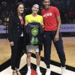 
              Las Vegas Aces chief business development officer Jennifer Azzi, left, and A'ja Wilson, right, present a custom leather jacket to Seattle Storm guard Sue Bird before a WNBA basketball game Sunday, Aug. 14, 2022, in Las Vegas. The game was Bird's final regular-season WNBA game. (AP Photo/Sam Morris)
            