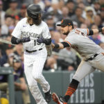
              San Francisco Giants third baseman J.D. Davis, right, tags out Colorado Rockies' Charlie Blackmon who got caught in a rundown between third and home plate while trying to advance on a ground ball hit by Randal Grichuk in the third inning of a baseball game against the Saturday, Aug. 20, 2022, in Denver. (AP Photo/David Zalubowski)
            