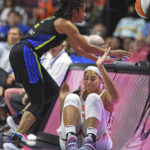 
              Dallas Wings guard Veronica Burton, left, chases the ball out of bounds and over Connecticut Sun center Brionna Jones, right, waiting to check into Game 1 of a WNBA basketball first-round playoff series Thursday, Aug. 18, 2022, in Uncasville, Conn. (Sean D. Elliot/The Day via AP)
            