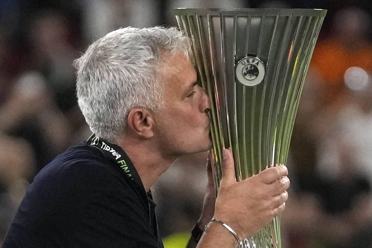 FILE - Roma's head coach Jose Mourinho kisses the Europa Conference League trophy at the end of the...