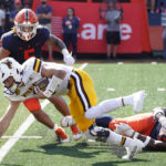 
              Illinois defensive lineman Jamal Woods, right, trips up Wyoming quarterback Andrew Peasley for a loss as linebacker Calvin Hart Jr. all defends during the first half of an NCAA college football game, Saturday, Aug. 27, 2022, in Champaign, Ill. (AP Photo/Charles Rex Arbogast)
            