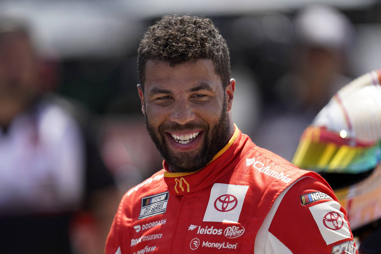 Bubba Wallace smiles during NASCAR Cup Series auto race qualifying at the Michigan International Sp...