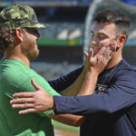 
              Oakland Athletics pitcher Cole Irvin, left, interrupts a hug to rub the face of former teammate New York Yankees pitcher Lou Trivino, right, before a baseball game in Oakland, Calif., Thursday, Aug. 25, 2022. (Jose Carlos Fajardo/Bay Area News Group via AP)
            