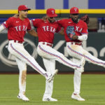 
              Texas Rangers outfielders Adolis Garcia, right, Bubba Thompson, center, and Leody Taveras dance together after the final out of a baseball game against the Detroit Tigers in Arlington, Texas, Friday, Aug. 26, 2022. (AP Photo/LM Otero)
            