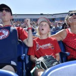 
              From left, Wyatt Smith, 17, of Waterville, Maine, Tessa Dutil, 9, of Sidney, Maine, and their grandmother Anne Smith, of Watervillle, Maine, react to a hit during the game between the Portland Sea Dogs and the Hartford Yard Goats, Sunday, August 28, 2022, at Hadlock Field in Portland, Maine. Across the northeastern U.S., outdoor businesses are profiting from the unusually dry weather. (AP Photo/Josh Reynolds)
            