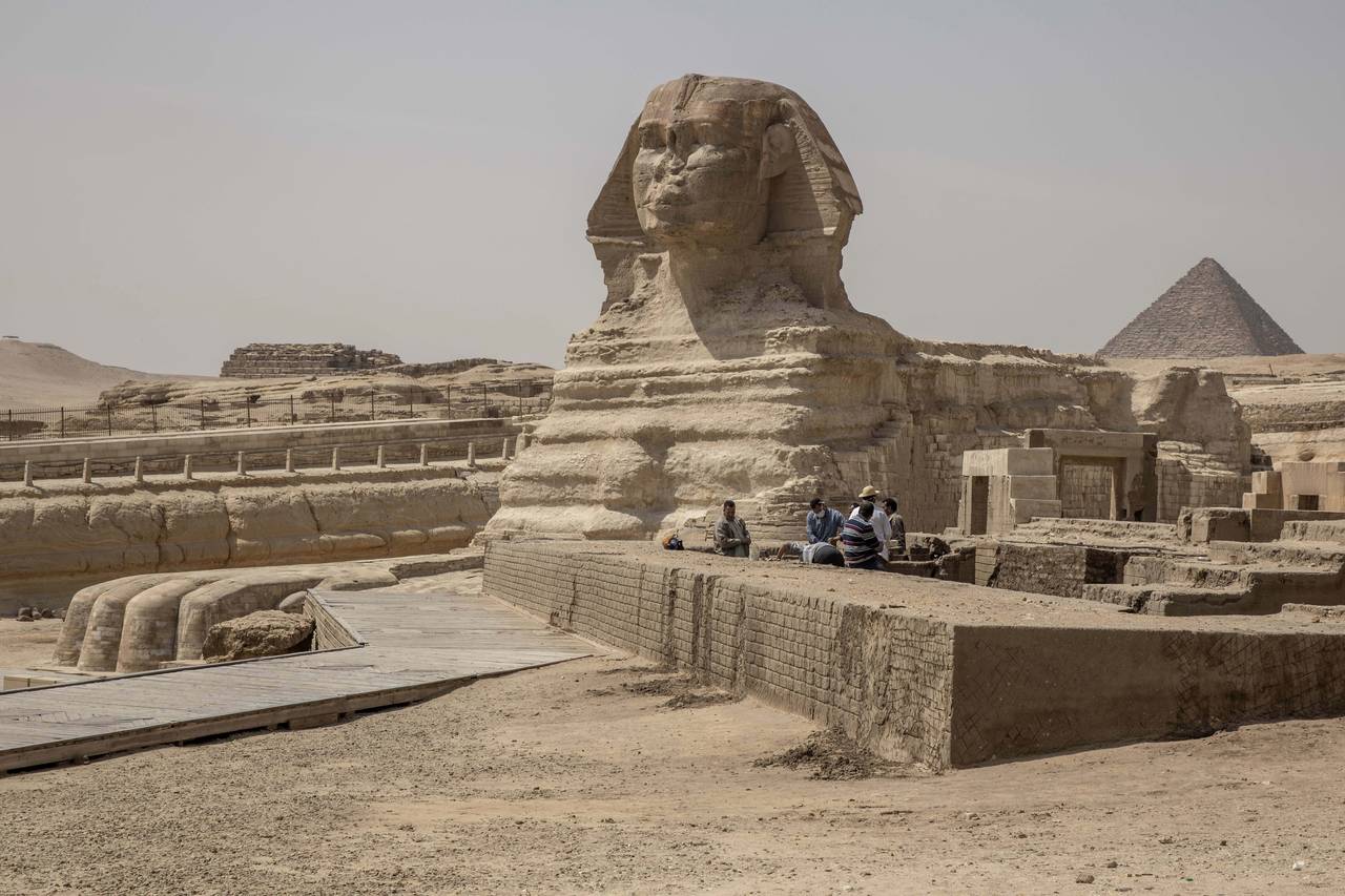 FILE - People work at the site of the Sphinx and the Giza Pyramids, in Giza, Egypt, Wednesday, Marc...